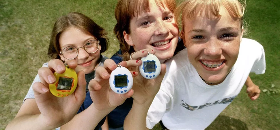 Drei Freundinnen halten stolz ihre Tamagotchis in die Kamera, 1997