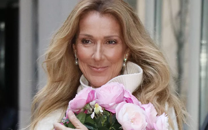 Blonde Frau hält ein Bouquet Blumen in der Hand